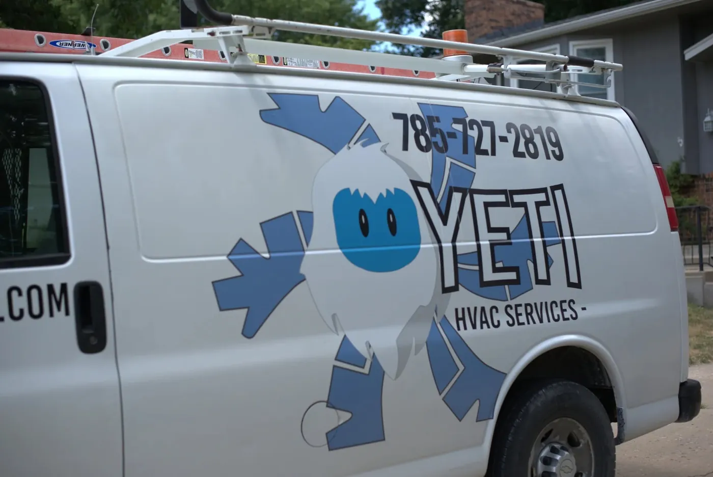 White Yeti HVAC service van with roof ladder racks and the yeti mascot logo